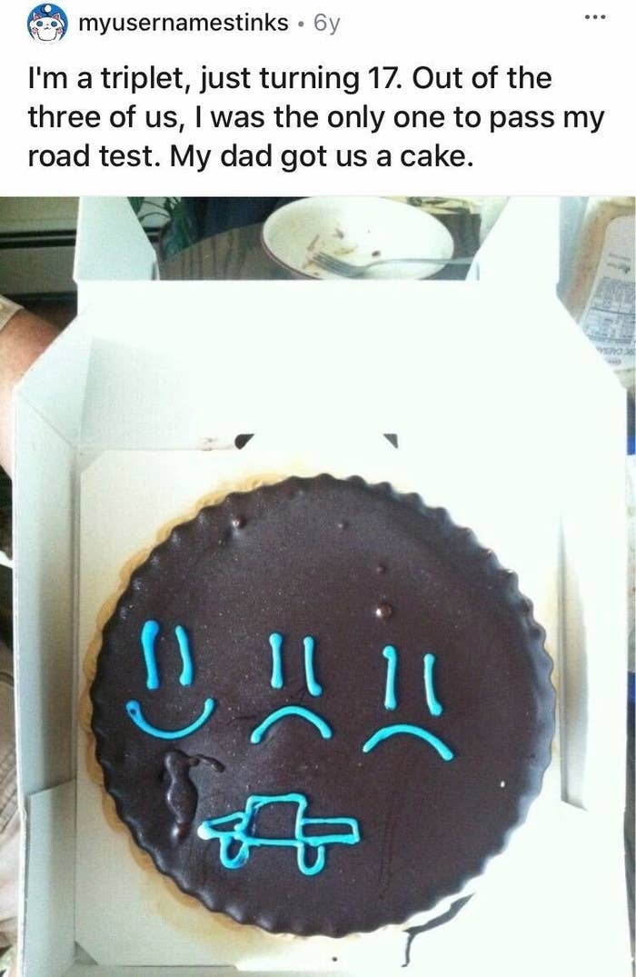 A cake decorated with two sad faces and one happy face gifted by a dad to his triplets for taking their driving test