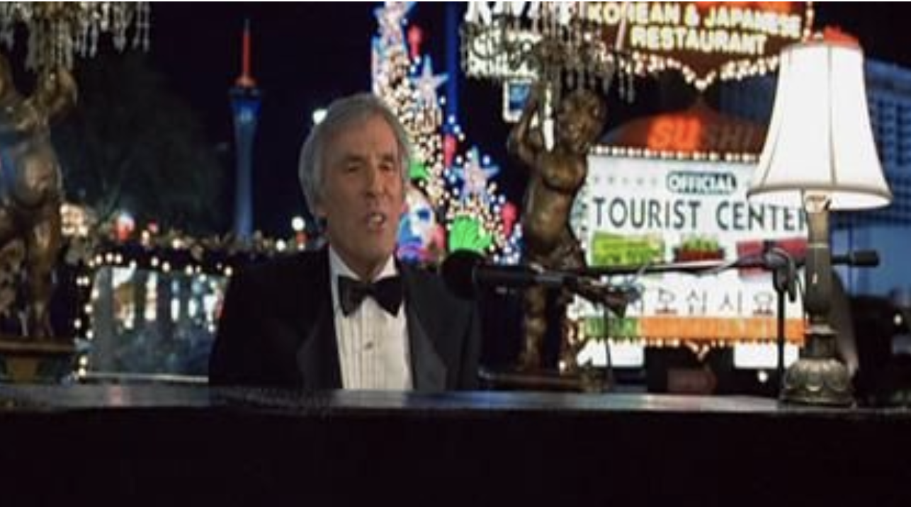 A tuxedoed Burt Bacharach playing a piano in Las Vegas