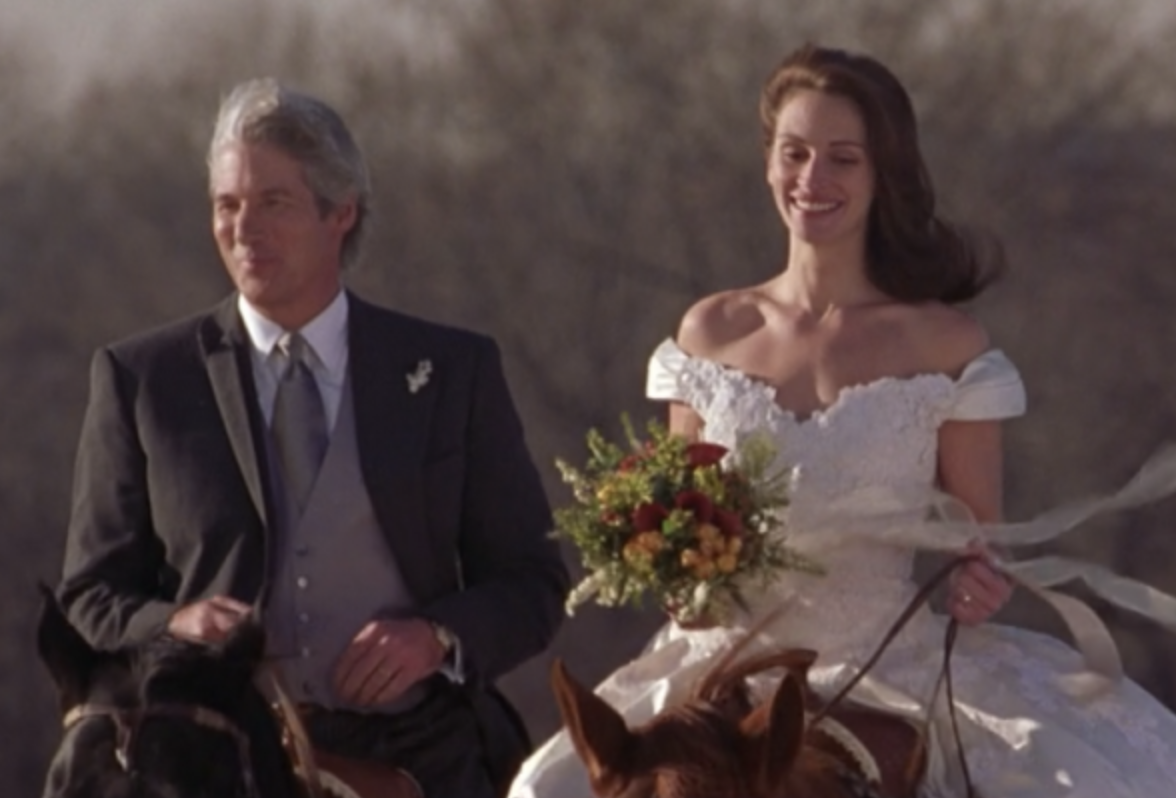 Maggie and Ike riding horses in their wedding attire