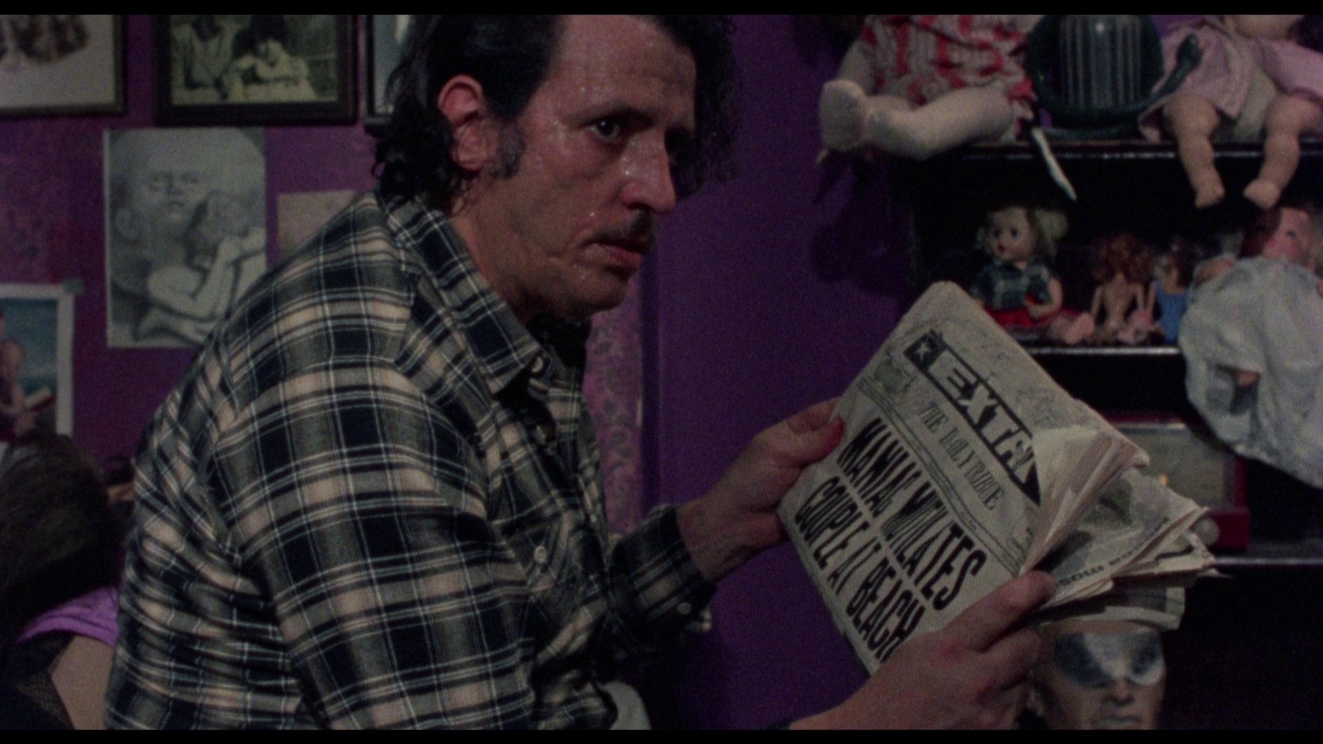 A creepy man reading a newspaper about horrific, murderous events