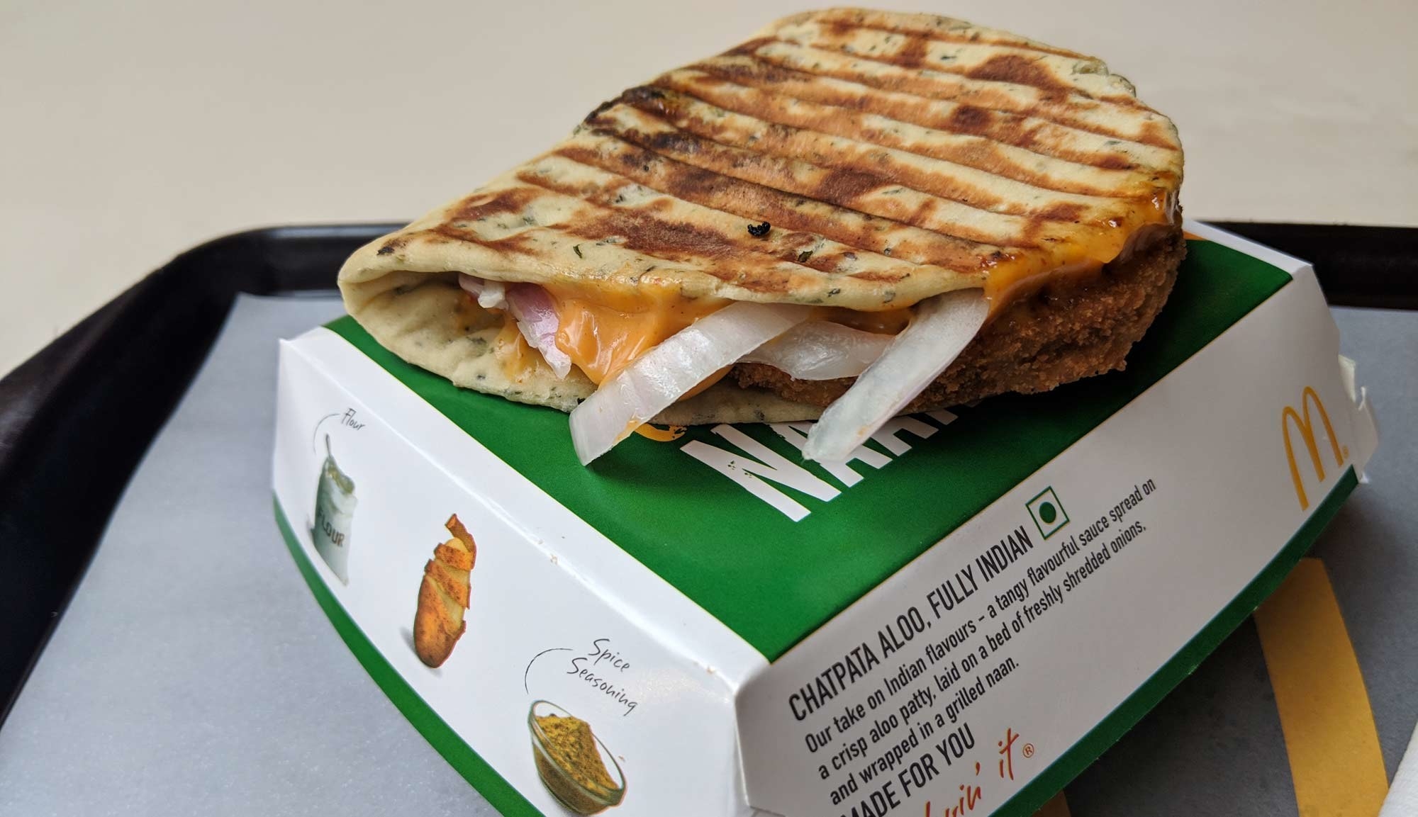 Image of Aloo Naan from McDonald&#x27;s India, with onions and a spicy sauce peeking out of it.