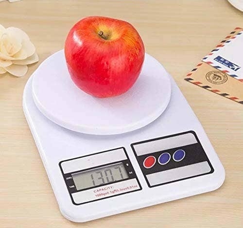 The digital kitchen scale pictured with an apple on it.