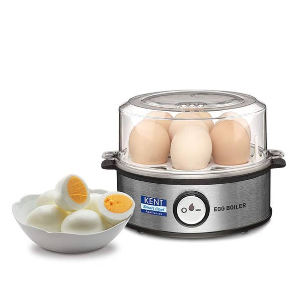 The egg boiler pictured with eggs in it, next to a bowl of boiled and peeled eggs.