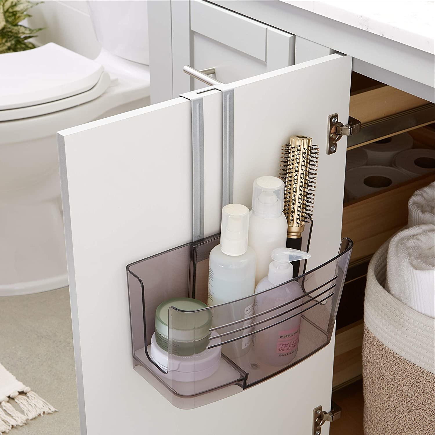 An open bathroom cabinet with the organizer on the door filled with beauty products