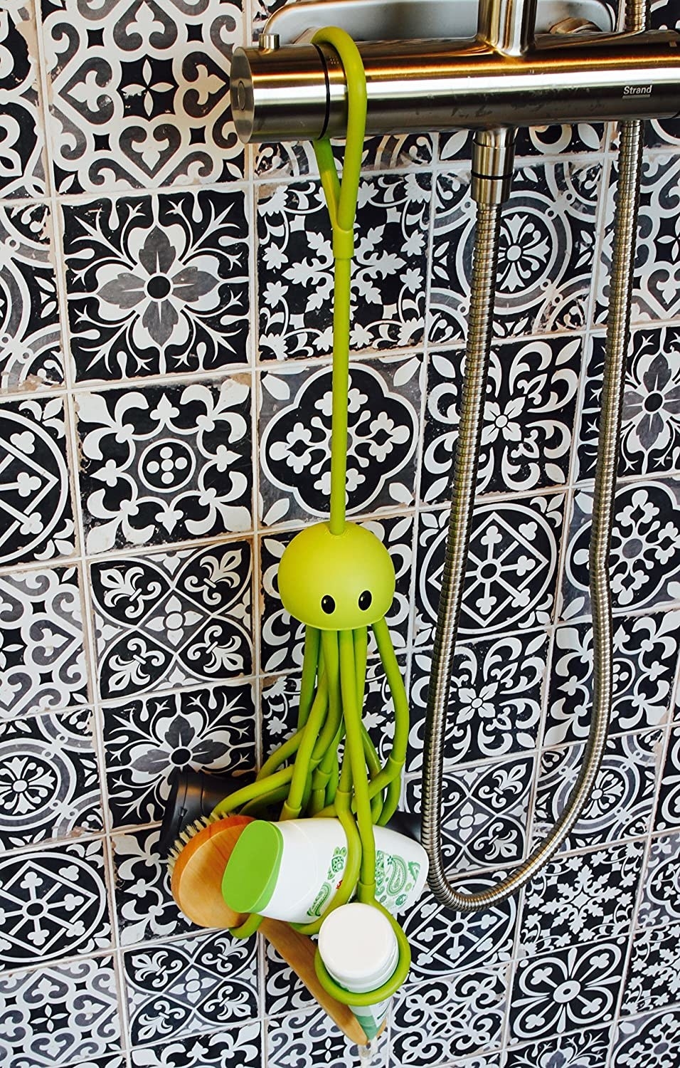 A hanging rubber octopus with several tentacles with round grippy ends. It is holding a brush, conditioner, shampoo, cleanser, and has room for more products.