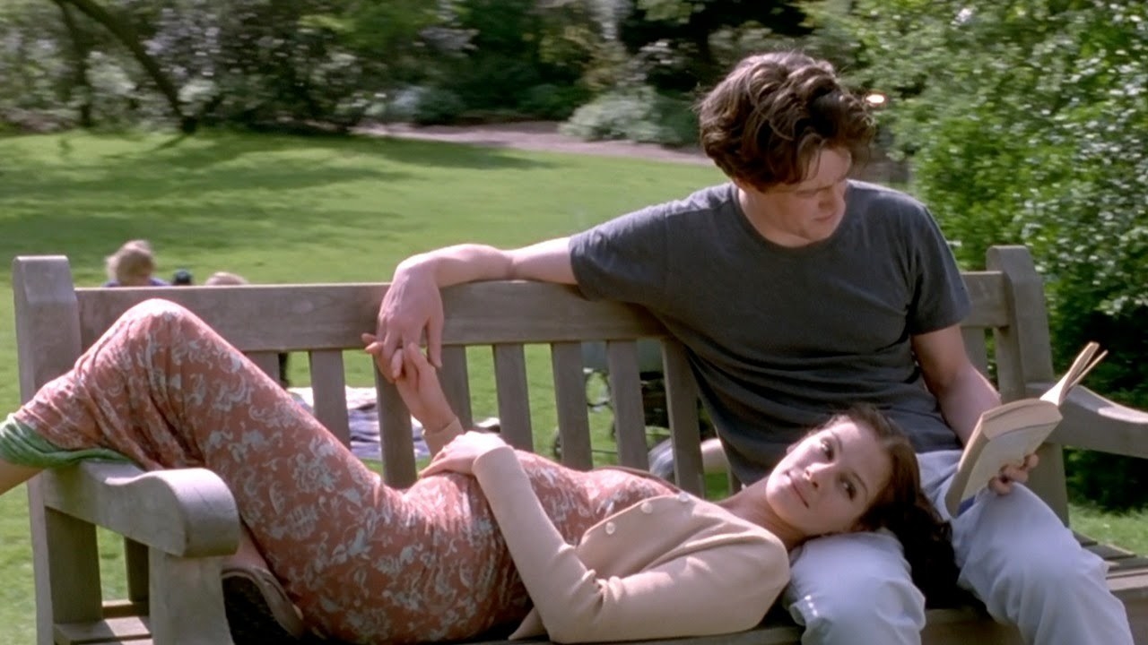 A pregnant Anna and Will sitting outside on a park bench
