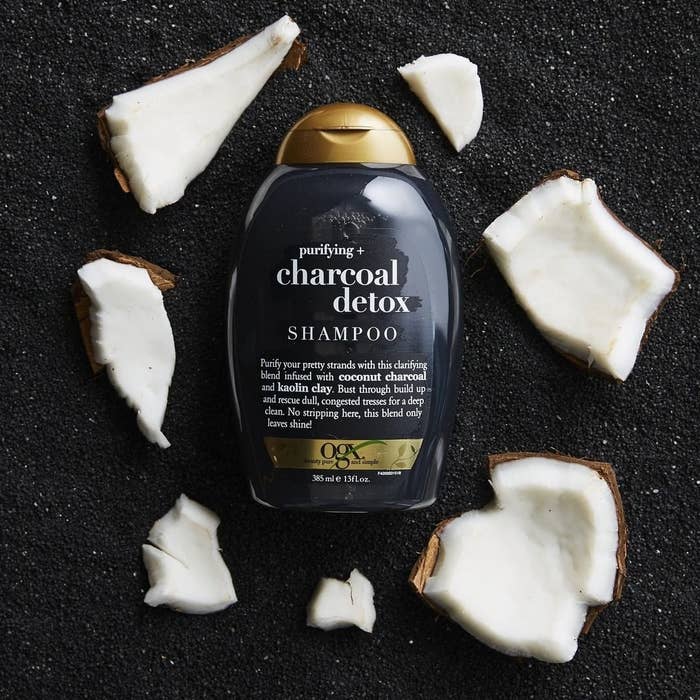 A flatlay of the shampoo bottle next to shattered shards of coconut