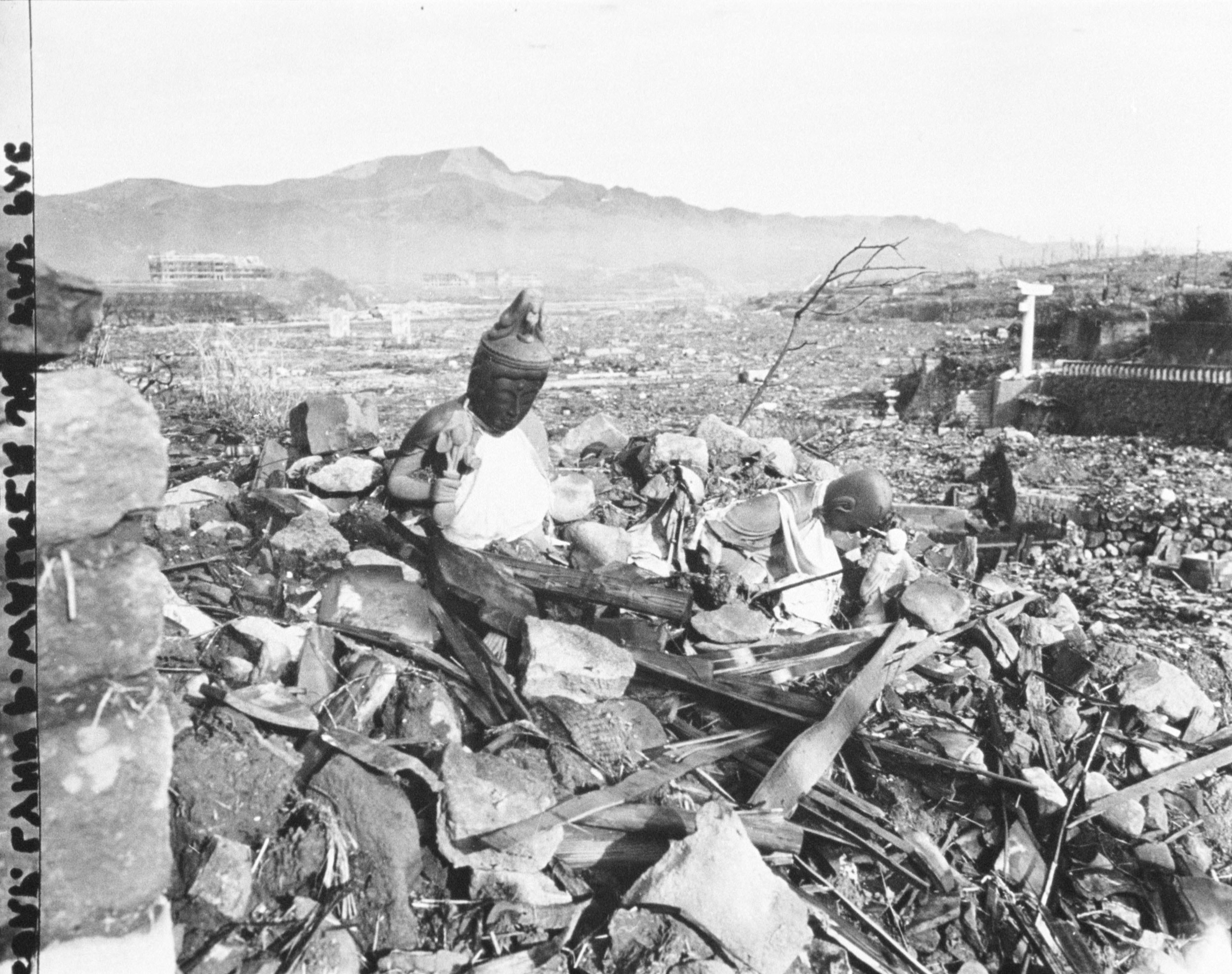 Two broken buddha statues rise out from the debris