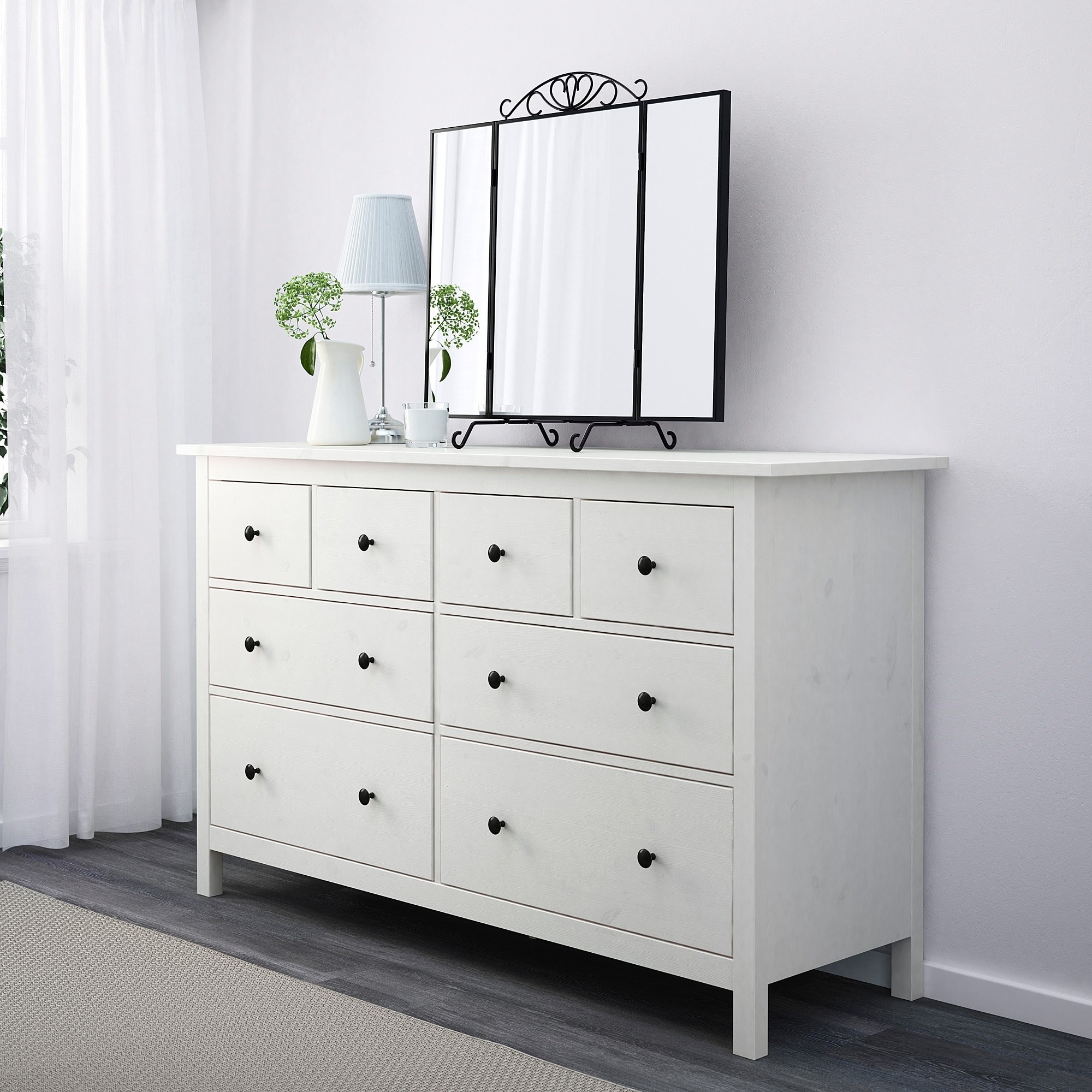 White dresser with eight drawers of different sizes and black handles