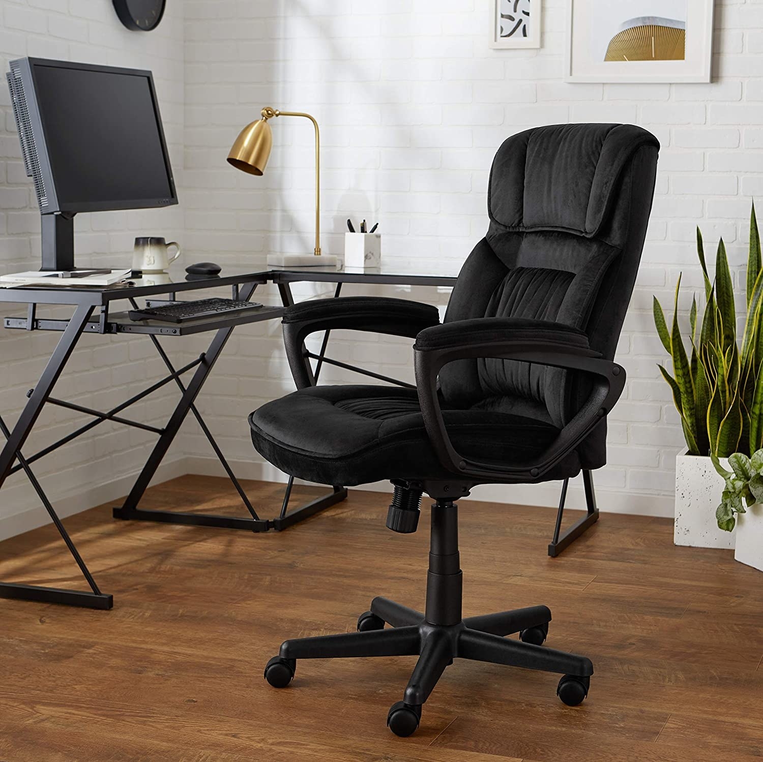 A large office chair with armrests sitting next to a desk