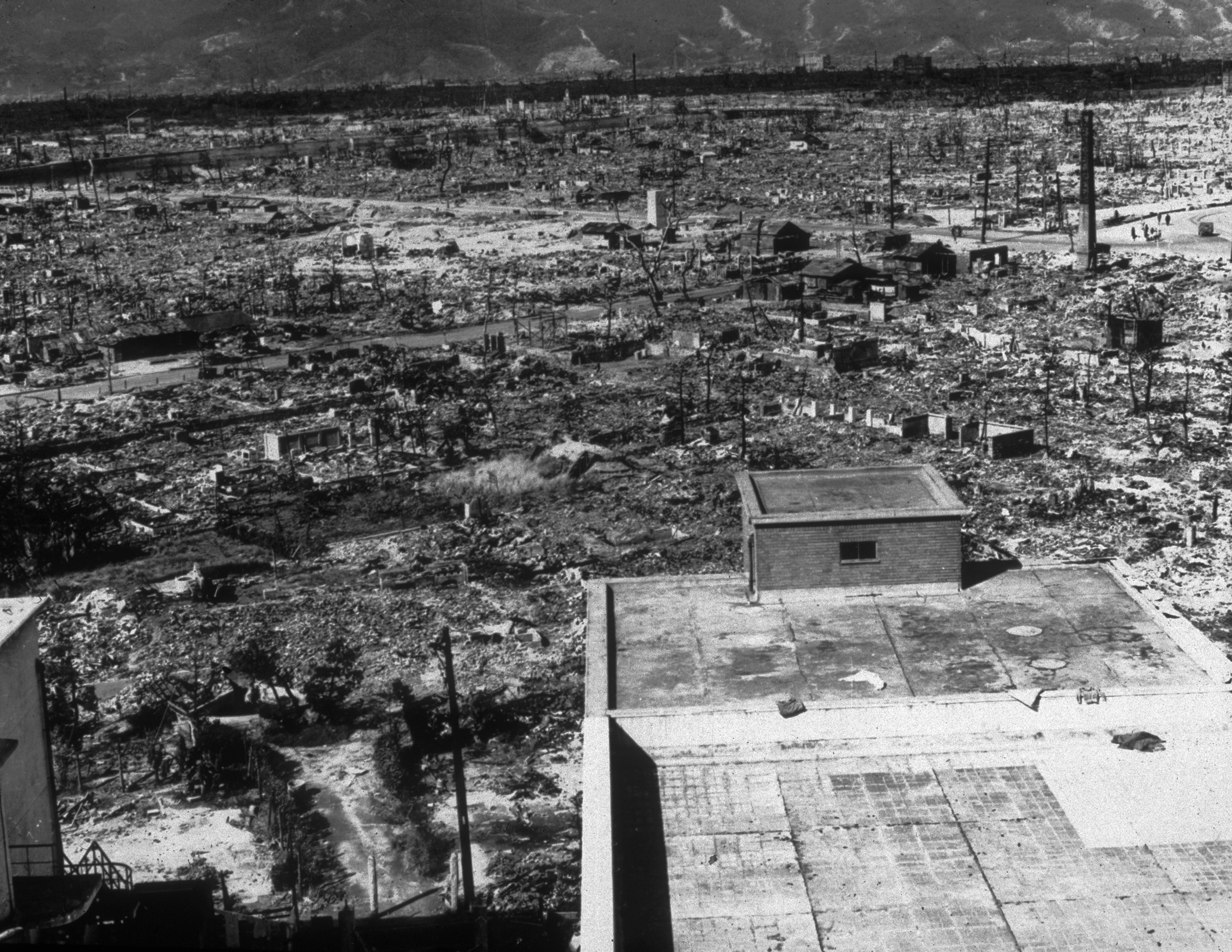 A single building appears in the foreground of miles of landscape reduced to rubble