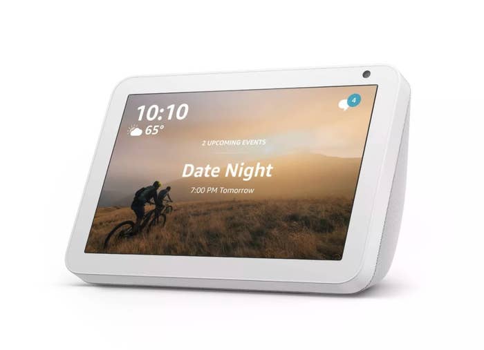 A white Echo Show with a screen showing the time and weather 