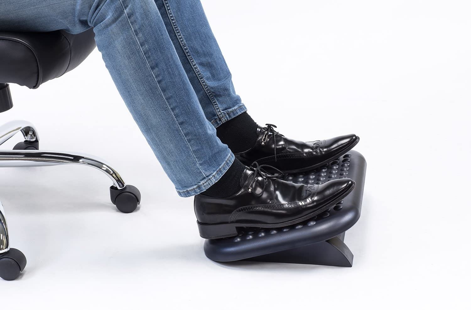 A person placing their feet on a foot rest that has a bumpy surface