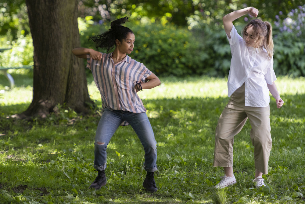 Two girls dance in a park 