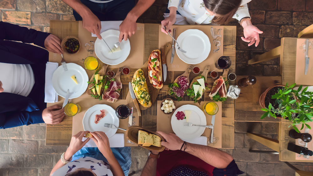 A table is set with meats,cheeses and toasts.