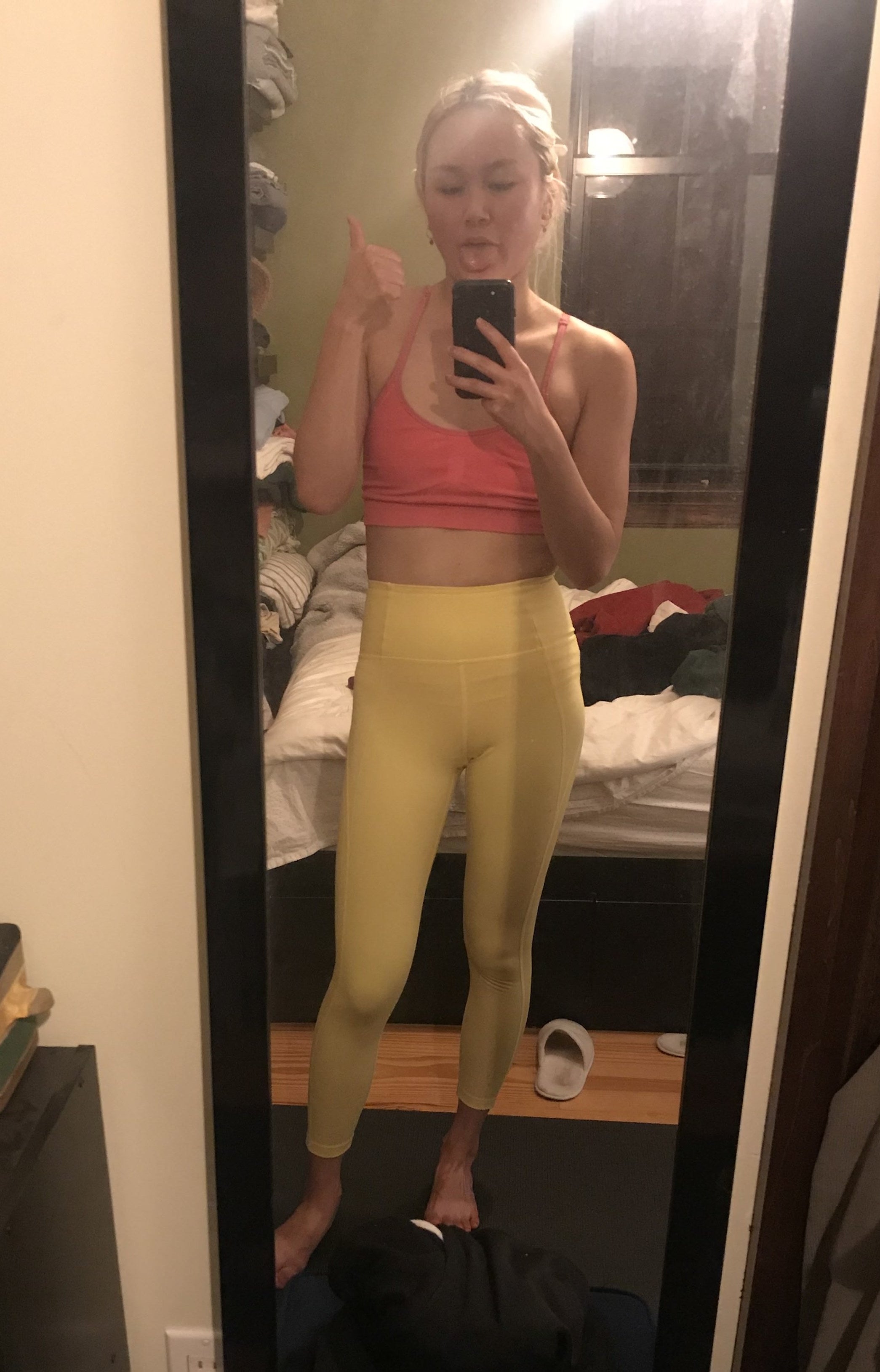 BuzzFeed editor wearing the leggings in yellow with coral sports bra