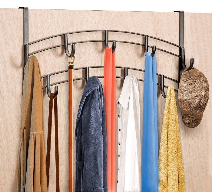 The two-rack, nine-hook organizer over a door with jackets, a hoodie, scarves, a belt, a bag, and a cap hanging on the hooks
