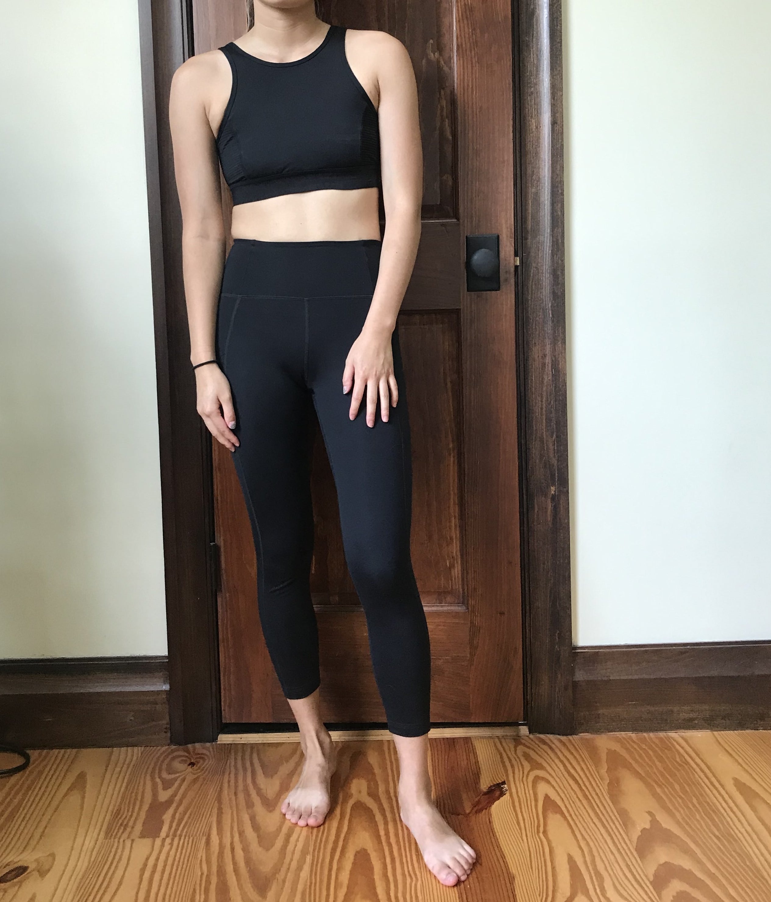 BuzzFeed editor wearing the leggings in black with black sports bra