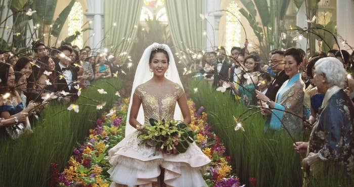 Araminta walking down a floral aisle in an extravagant wedding dress