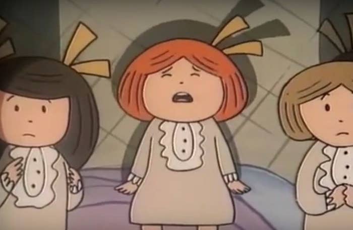 Madeline, a little girl with orange hair, sitting on a bed crying