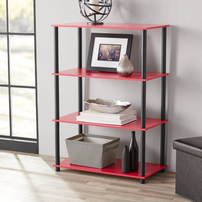 an open bookcase with red shelves