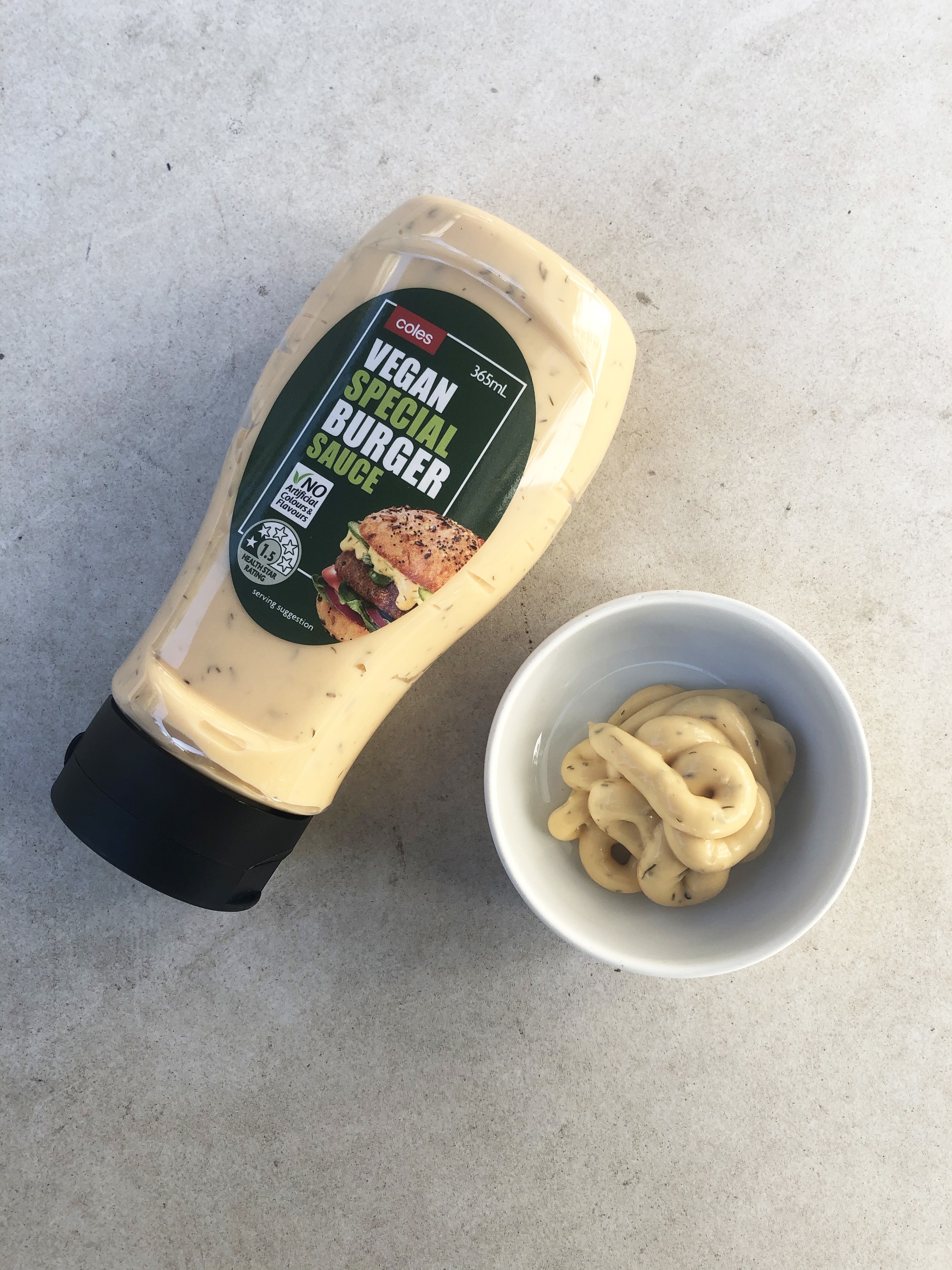 The Coles Vegan Special Burger Sauce bottle alongside a small bowl filled with some of the sauce