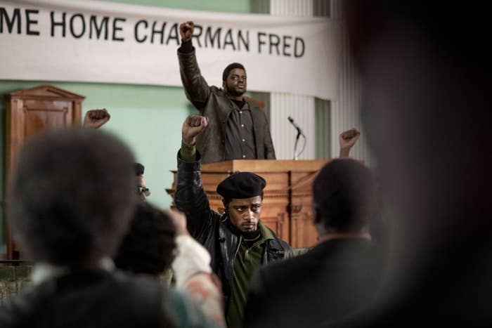 A scene from the movie at a Black Panther meeting with members raising their fists in unity