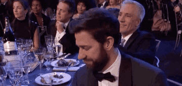 GIF of John Krasinski clapping at an award ceremony.