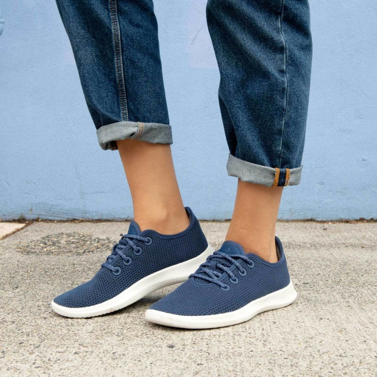 Model wearing the knit sneakers in blue with blue laces and white soles