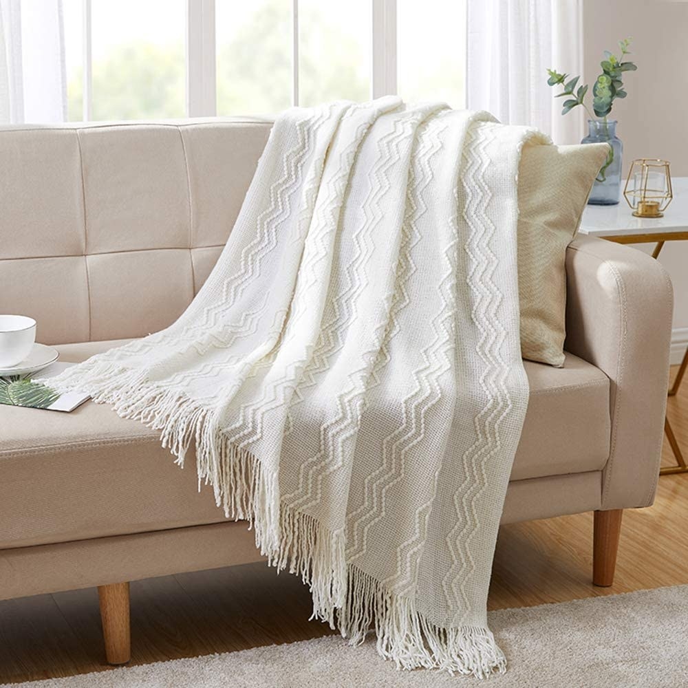 The textured throw blanket draped over a sofa