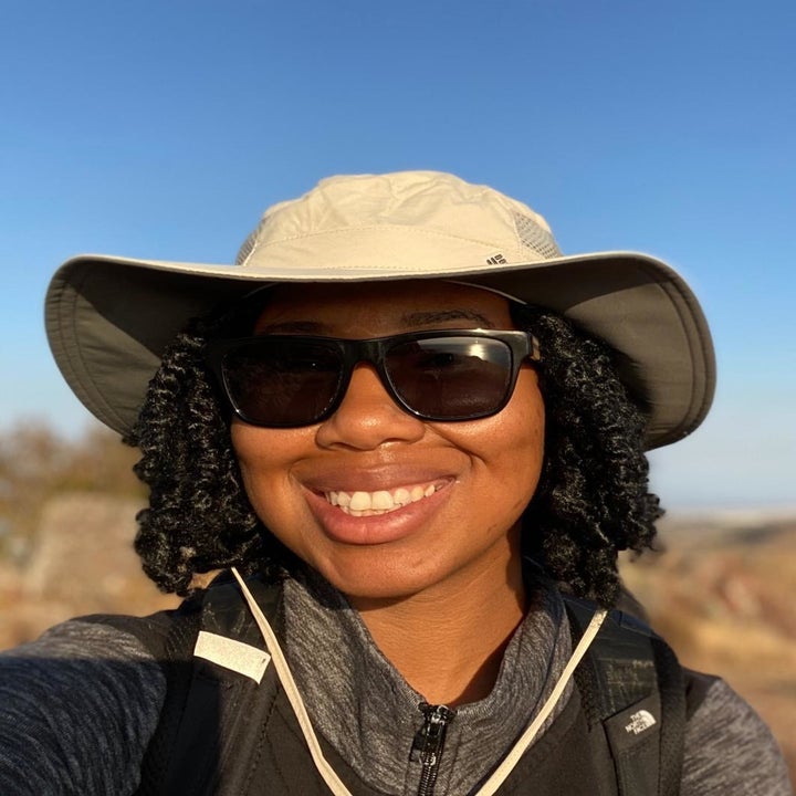 reviewer in a tan floppy brimmed hat with a neck strap