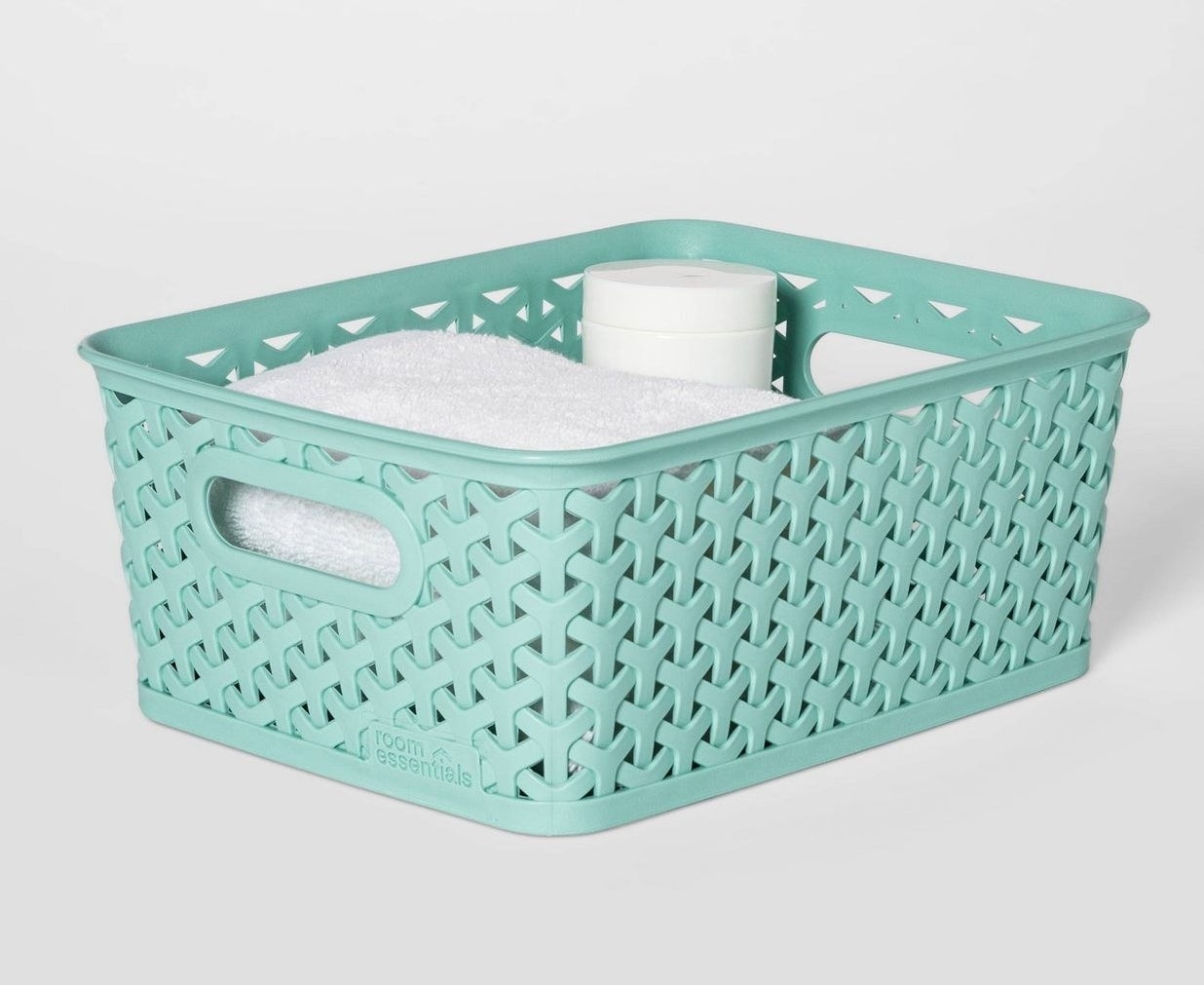 The woven plastic bin in mint, holding small towels and wipes