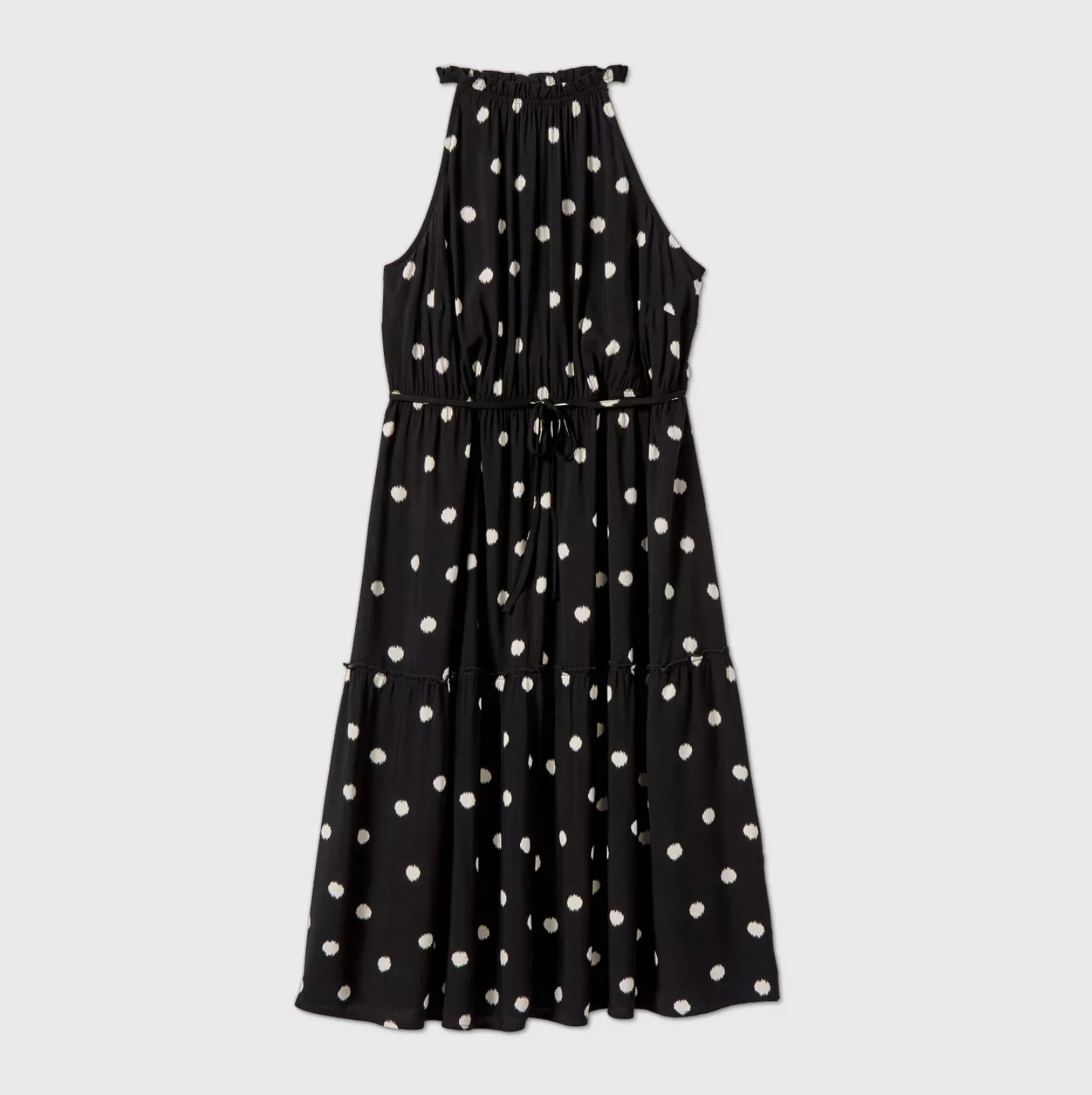 An image of a midi-length black sleeveless dress with white polka dots and a halter neckline