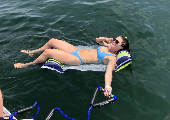 Reviewer relaxing on the float, which has a pillow for the neck and the legs