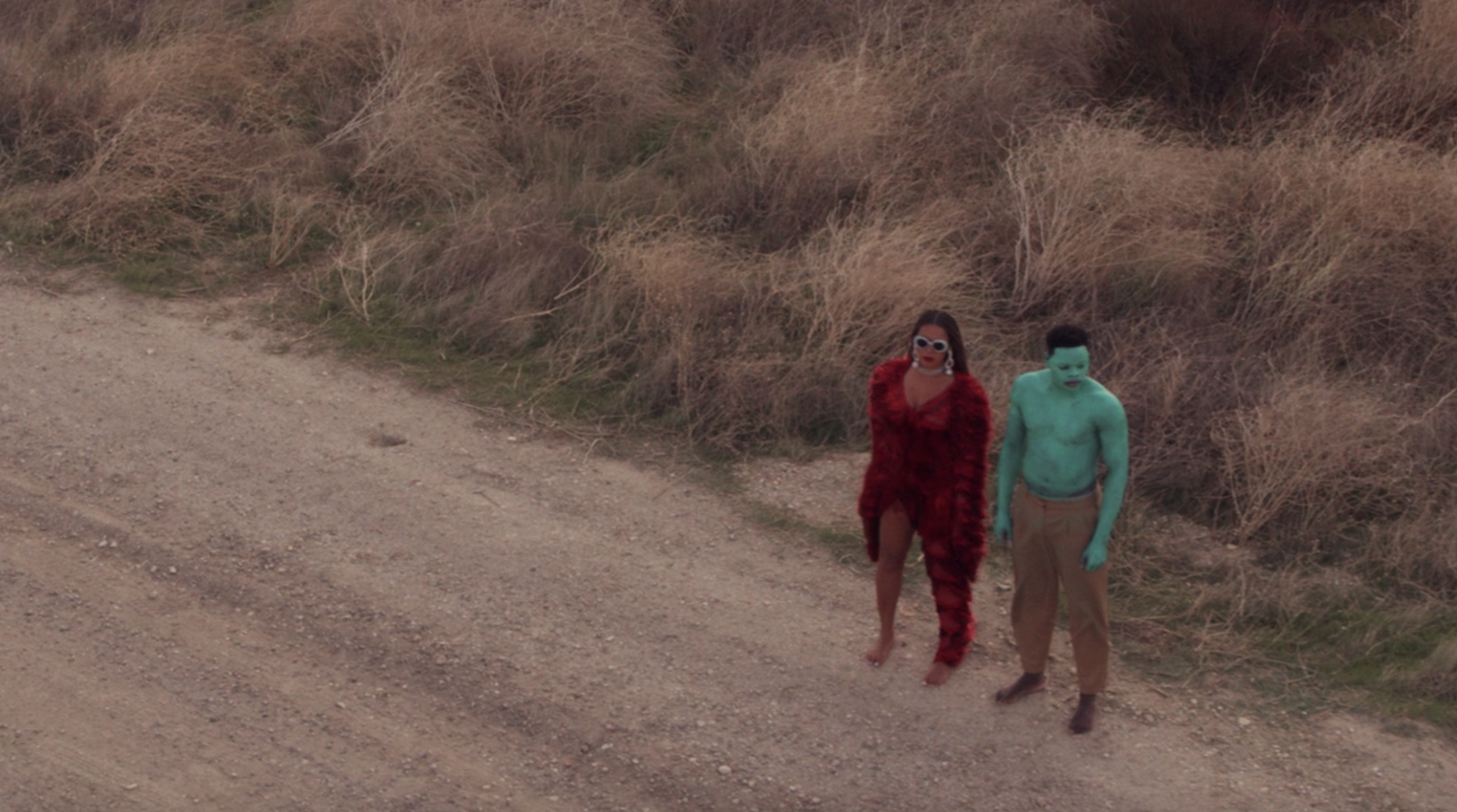 Papi Ojo stands next to Beyoncé on a dirt road as the blue man in &quot;Black Is King&quot;