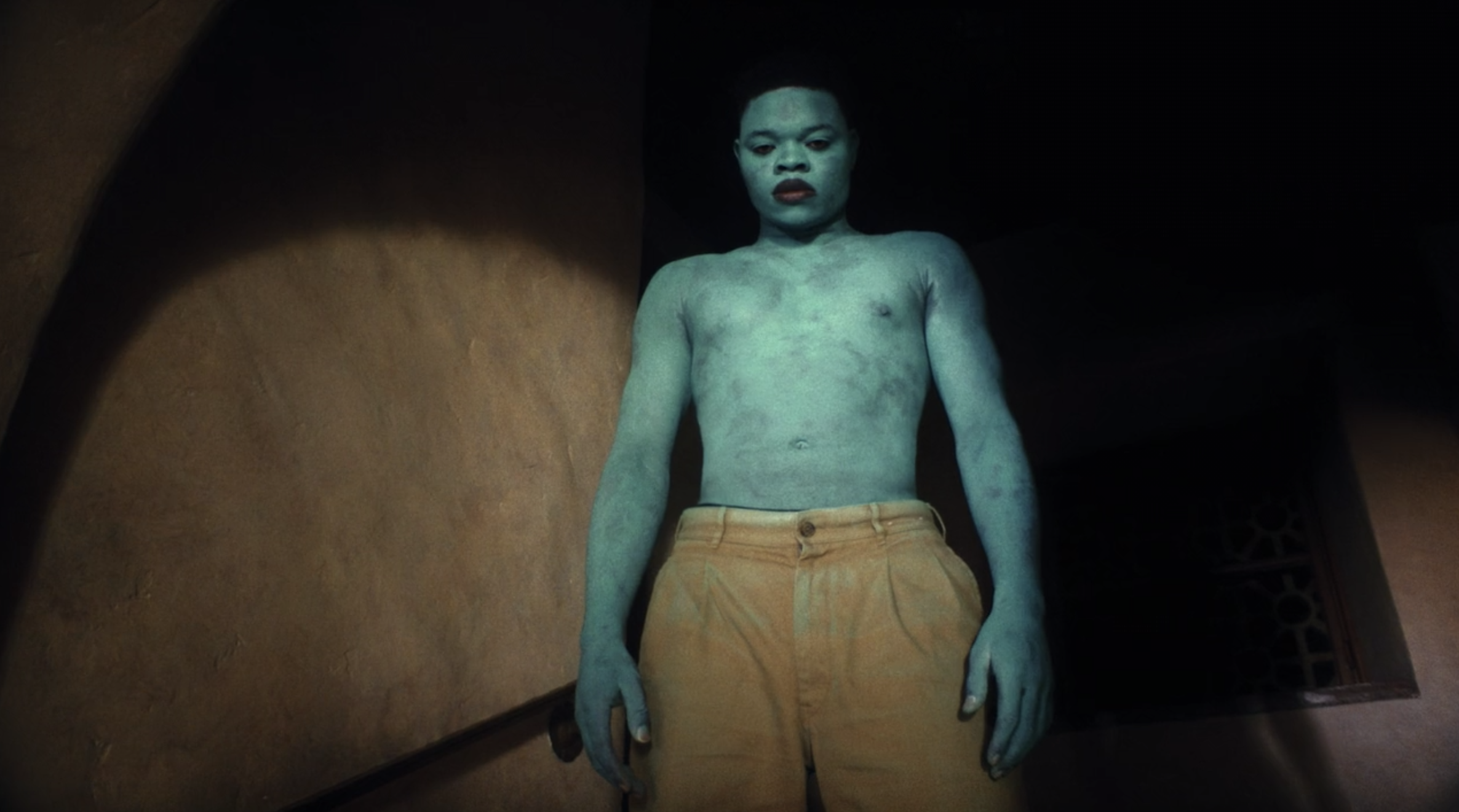 Papi Ojo stands on a staircase the blue man in &quot;Black Is King&quot;