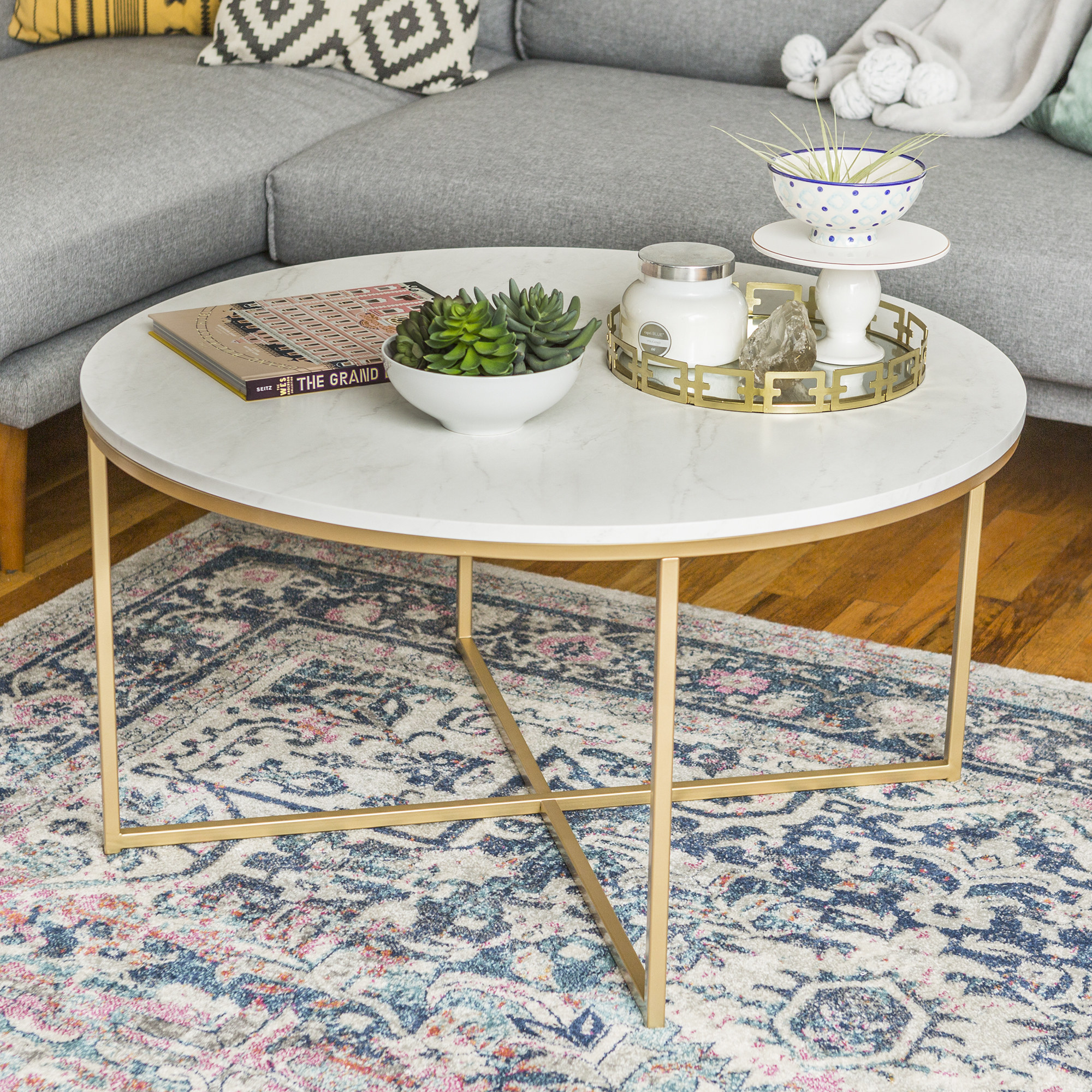The coffee table, featuring a faux marble top and gold legs