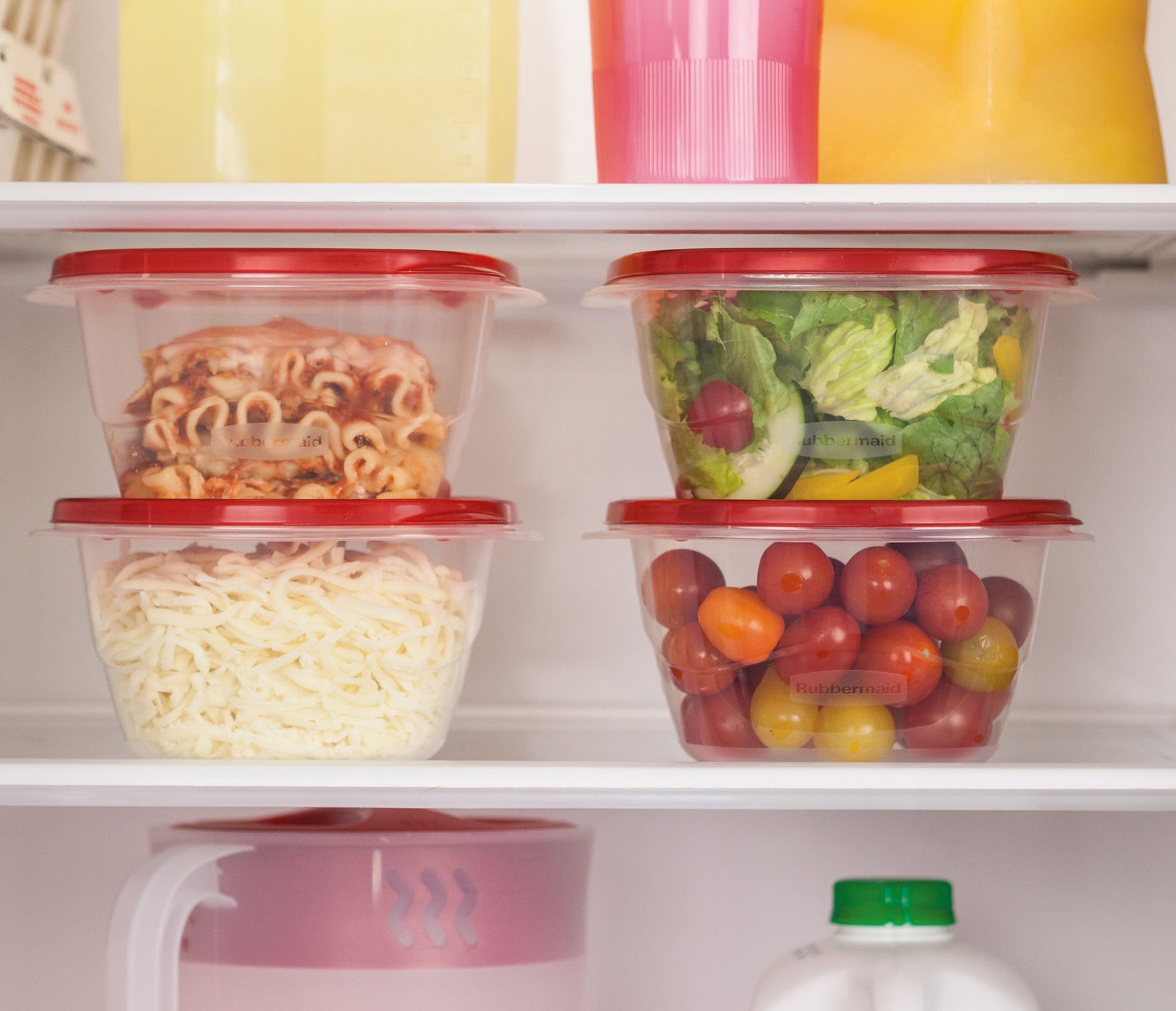 four food containers with red lids holding various leftovers in a fridge