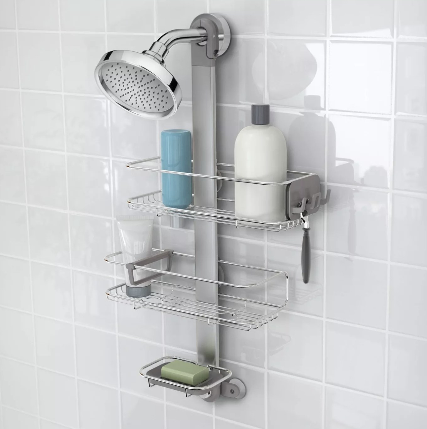A 3-tier shower caddy attached to the shower head holding three body products, a bar of soap, and a razor