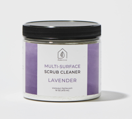 A clear container that says &quot;PUR Home Multi-Surface Scrub Cleaner&quot; on the front