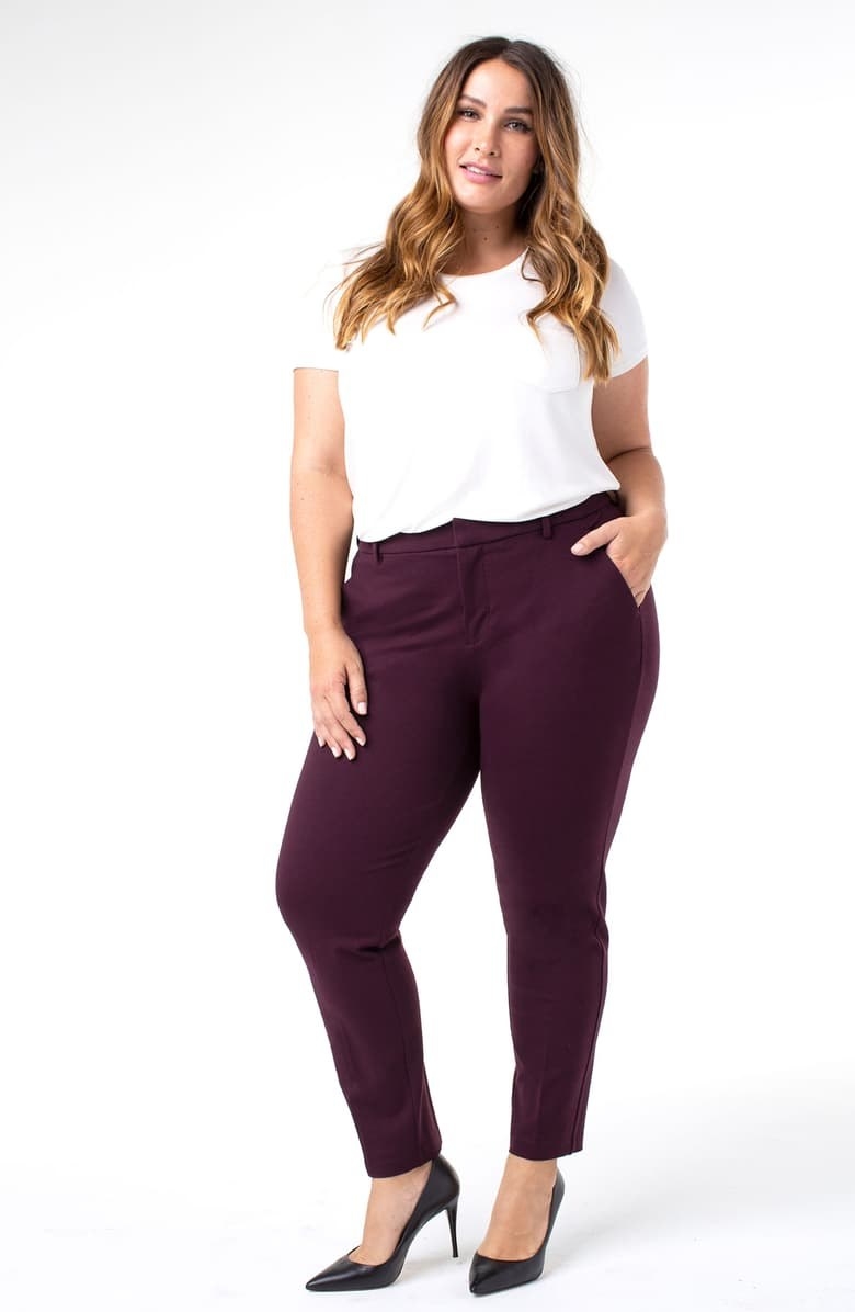 A plus size model wears the Liverpool Kelsey Ponte Knit Trousers in aubergine