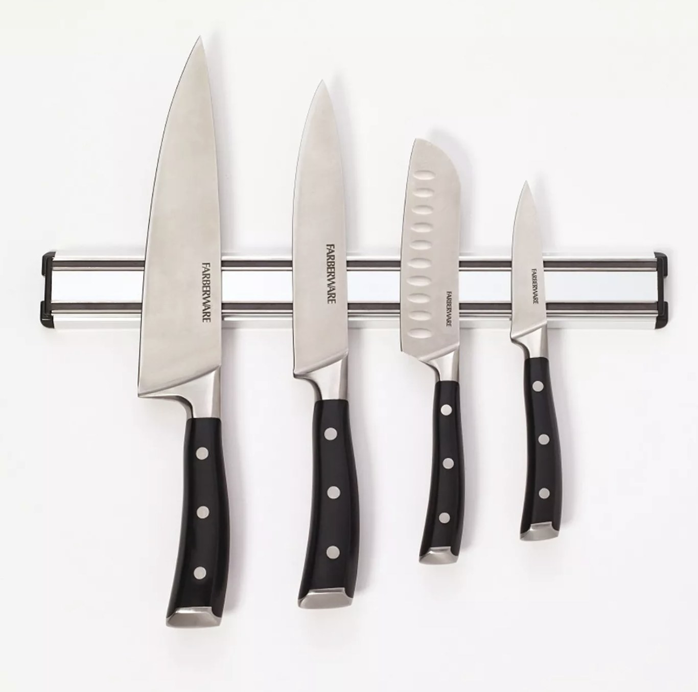 A set of four knives hanging on a magnetic strip