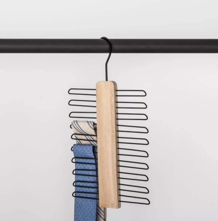 A wooden hanger with 20 rings holding two ties.