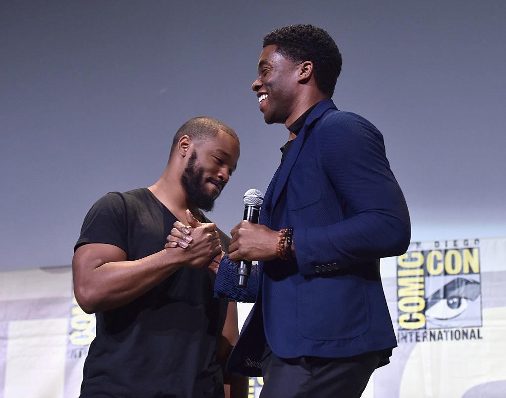 Ryan Coogler and Chadwick Boseman exchanging a warm handshake at a Comic Con panel