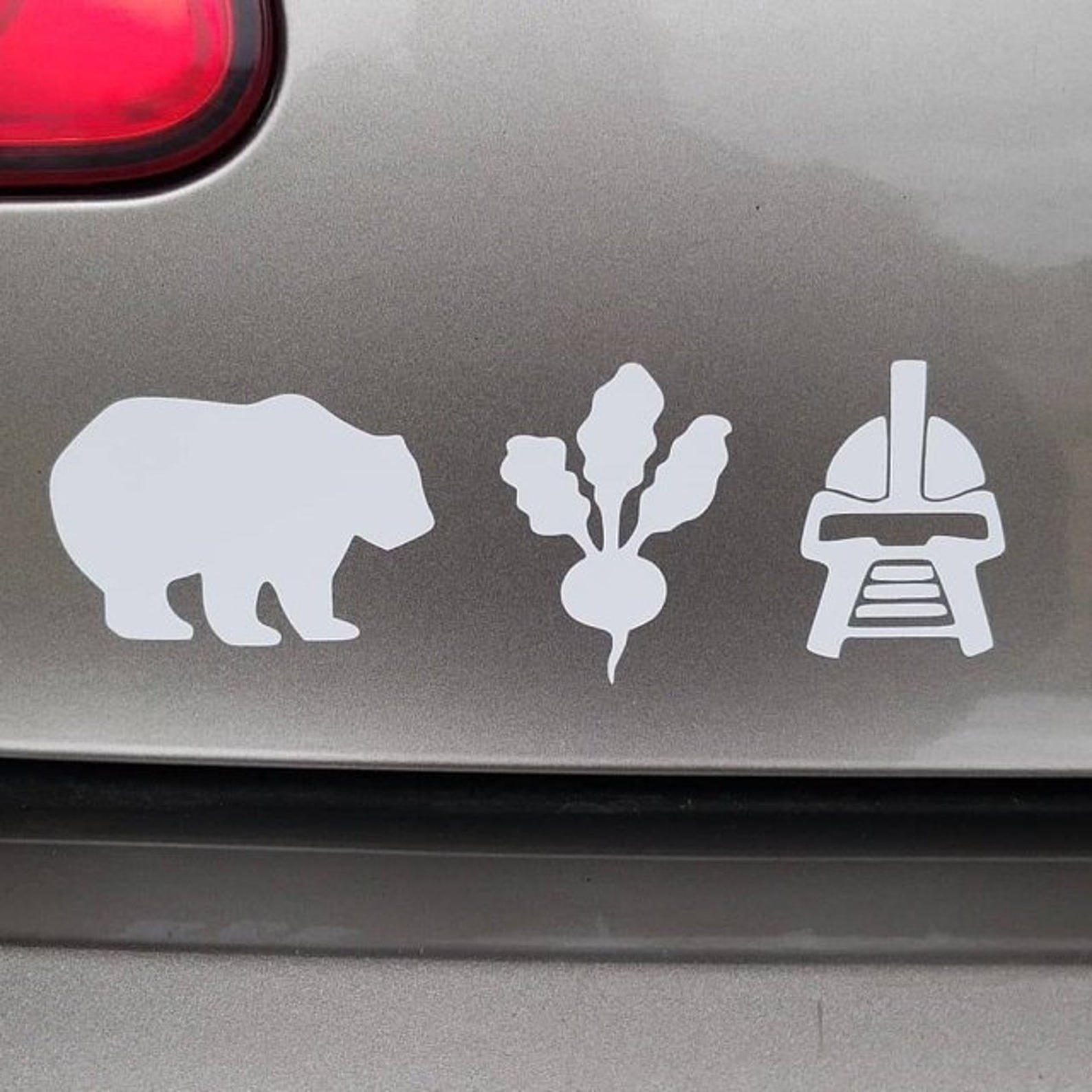 a bear, beet, and Battlestar Galactica decal on a car