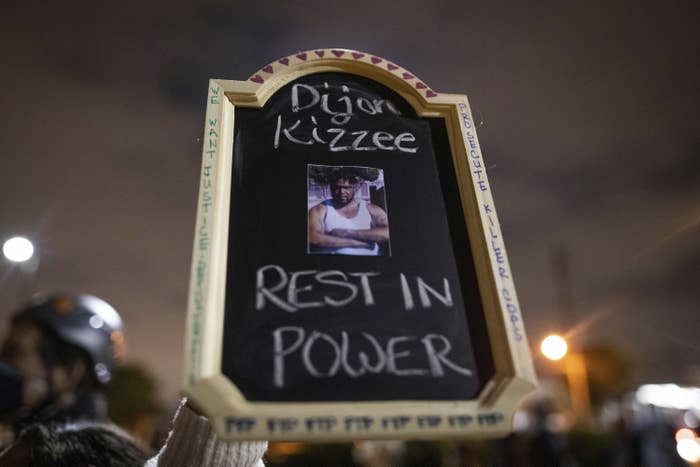 The sign says "Dijon Kizzee, rest in power"