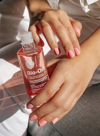 A model rubbing bio-oil on their hands 