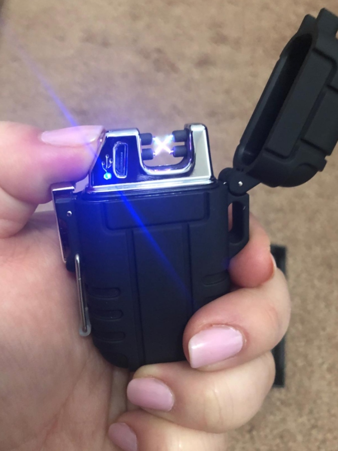 A reviewer holding the small, black lit plasma lighter