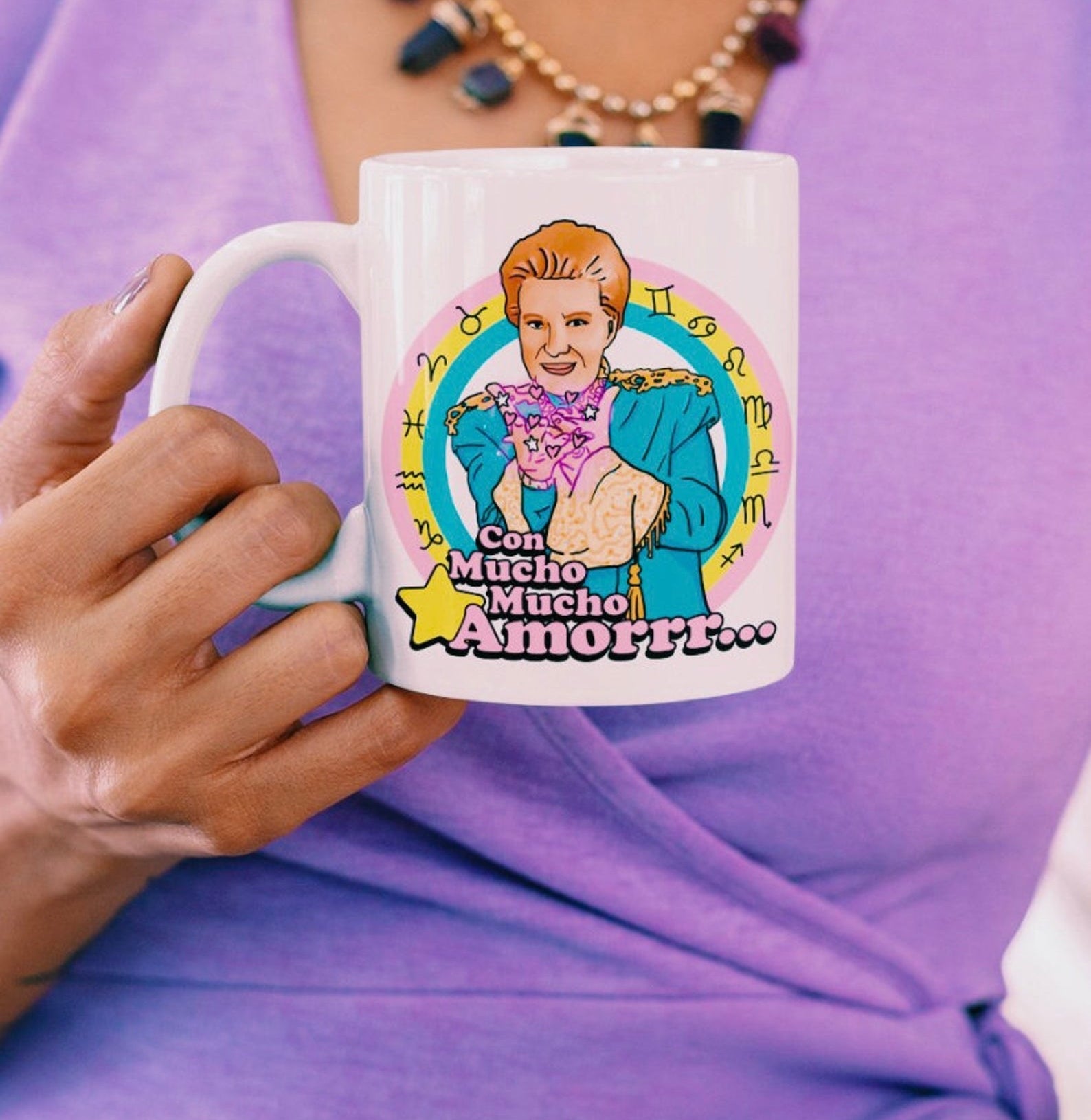 Model holding a white coffee mug with a colorful illustration of Walter Mercado 