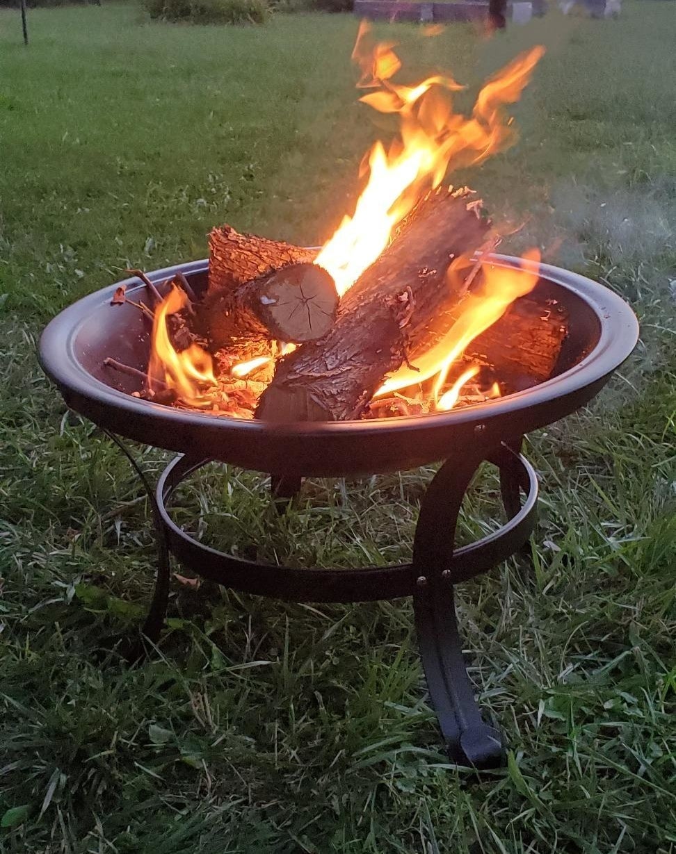 Reviewer photo of the medium-size fire pit with three large logs alight